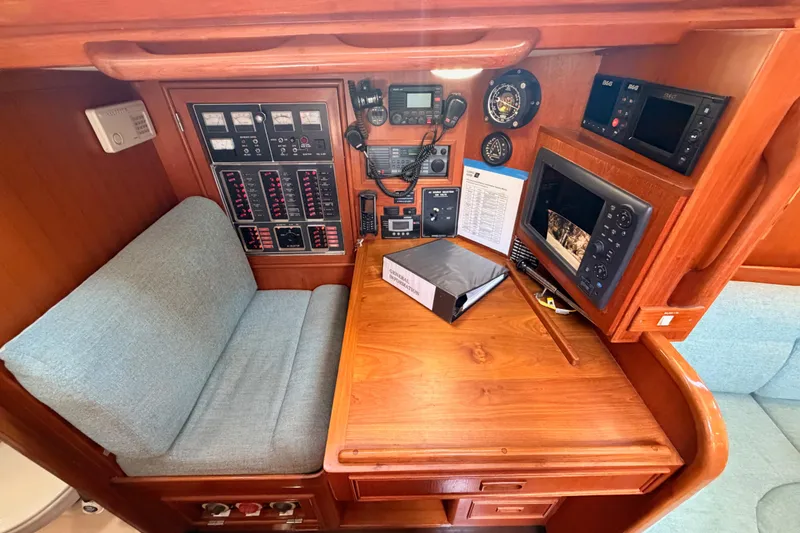 Slide: The Image of Navigation station of a 1991 Hylas 51 yacht with control panels and seating. - 58