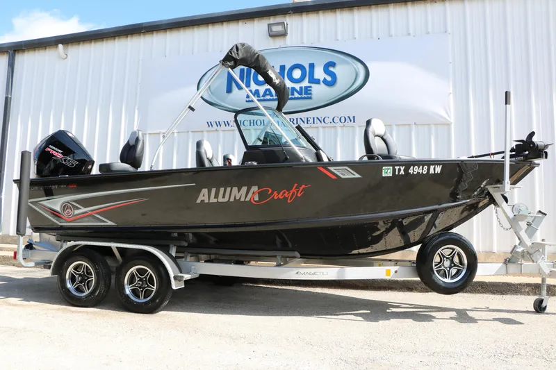 The Image of 2023 Alumacraft Competitor FSX 185 boat on trailer, parked outside Nichols Marine. - 1