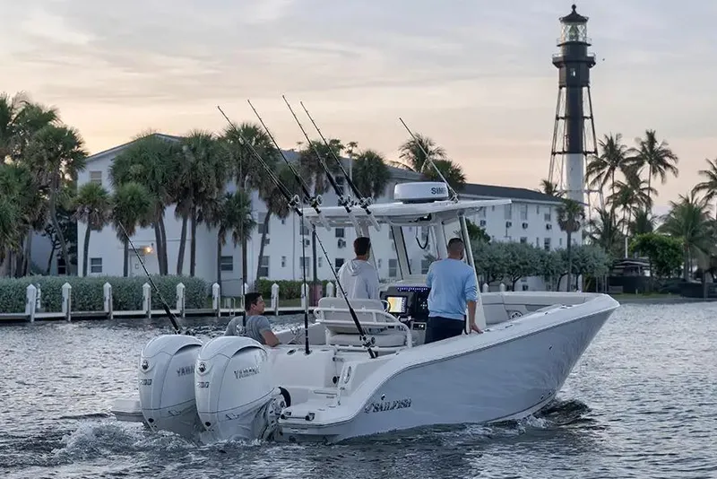 Slide: The Image of Manufacturer Provided Image: 2026 Sailfish 252 CC boat cruising near a lighthouse at sunset. - 2