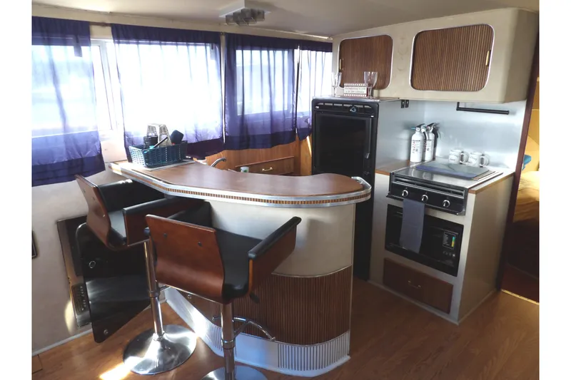 Slide: The Image of Interior of 1984 Chris-Craft 381 Catalina yacht with modern kitchen and bar seating. - 18