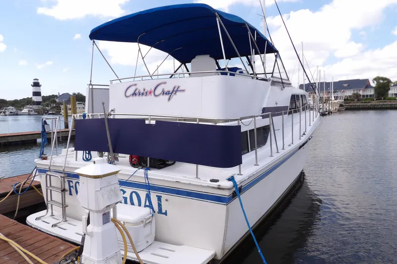 Slide: The Image of 1984 Chris-Craft 381 Catalina yacht docked at marina with lighthouse in background. - 6