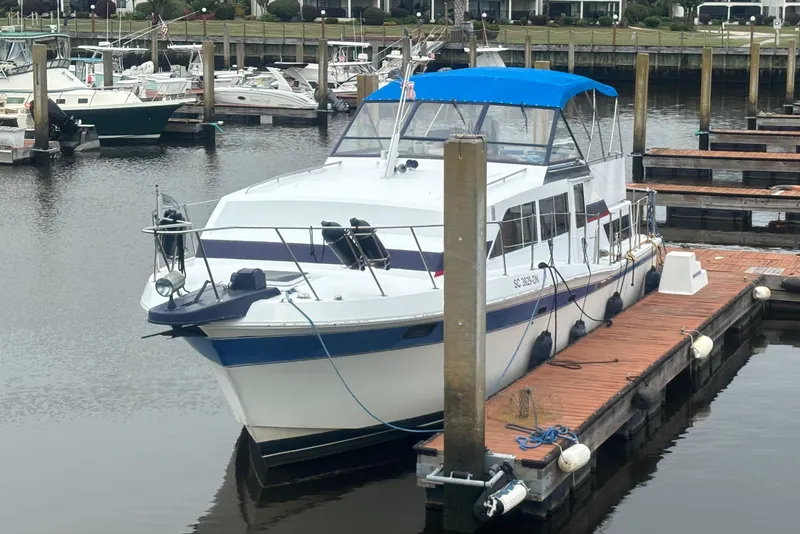Slide: The Image of 1984 Chris-Craft 381 Catalina docked at marina with blue canopy and white hull. - 1