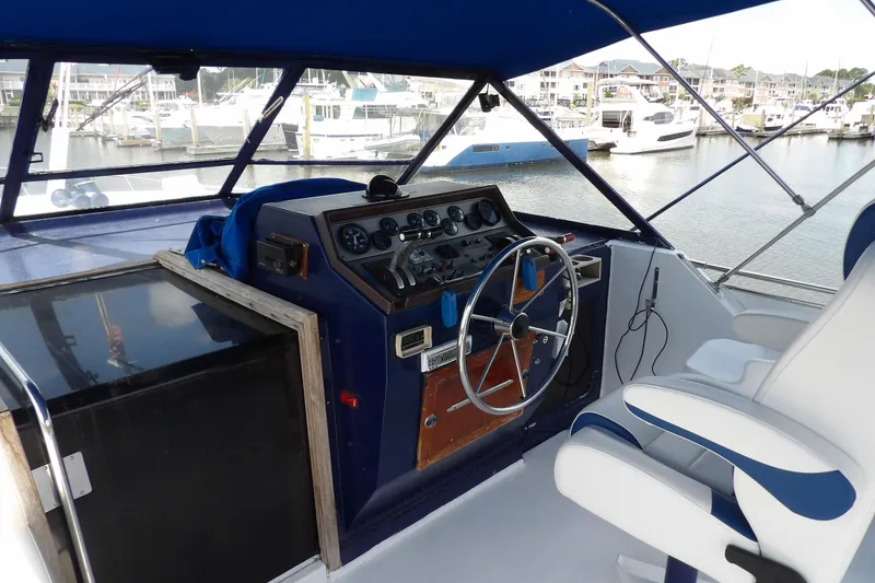 Slide: The Image of 1984 Chris-Craft 381 Catalina helm with steering wheel, gauges, and marina view. - 11