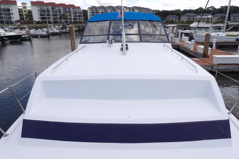 Slide: The Image of 1984 Chris-Craft 381 Catalina yacht docked at marina, showcasing sleek design and spacious deck. - 9