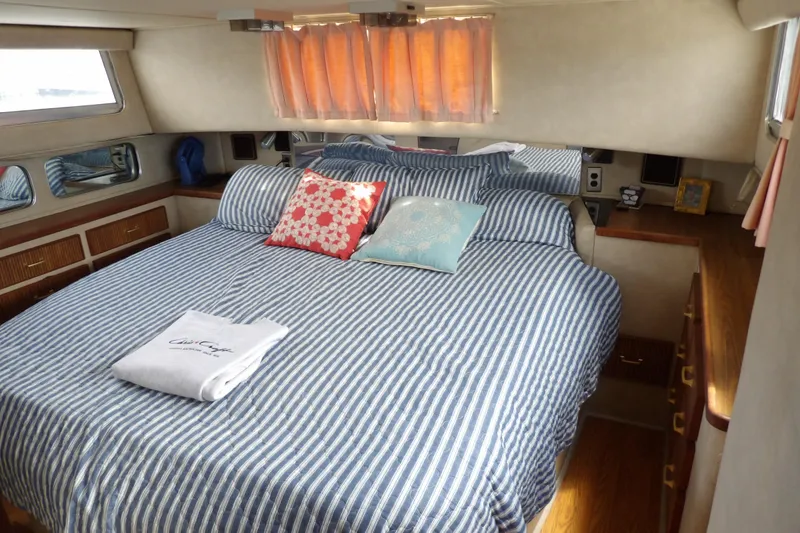 Slide: The Image of 1984 Chris-Craft 381 Catalina cabin interior with striped bedding and decorative pillows. - 27