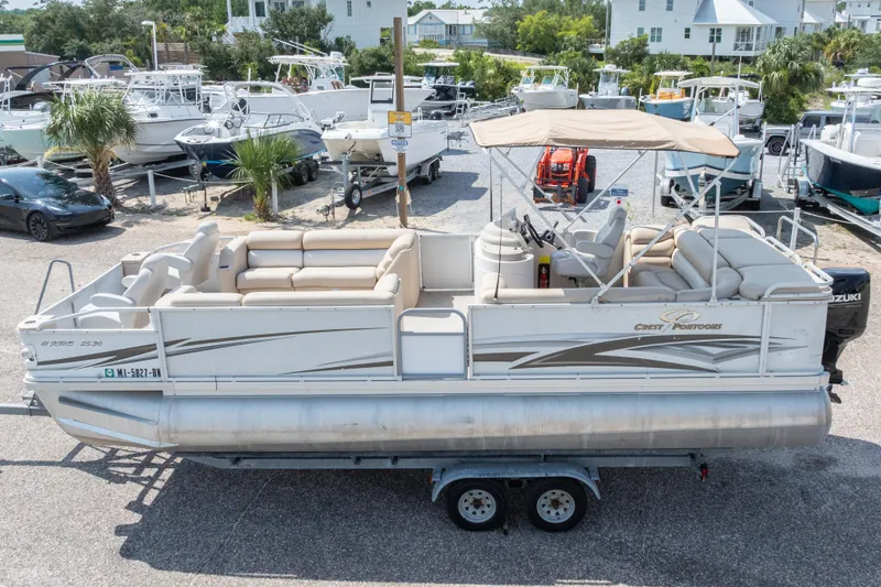 Slide: The Image of 2007 Crest 111 XRS pontoon boat with canopy, parked on trailer in marina. - 3