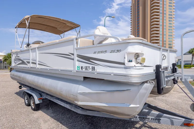 Slide: The Image of 2007 Crest 111 XRS pontoon boat on trailer, parked near a tall building. - 9
