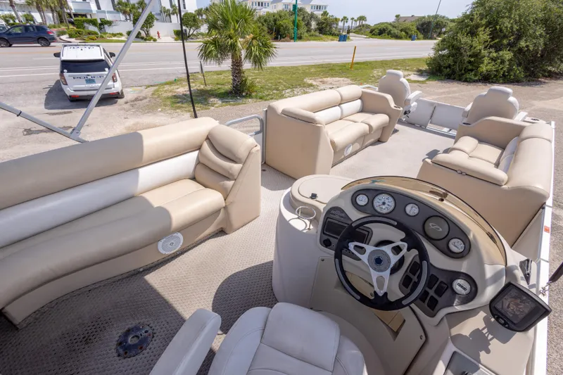 Slide: The Image of 2007 Crest 111 XRS pontoon boat interior with beige seating and steering console. - 23