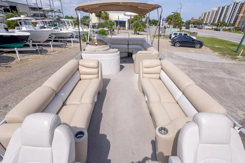 Slide: The Image of 2007 Crest 111 XRS pontoon boat with beige seating, parked near other boats. - 19