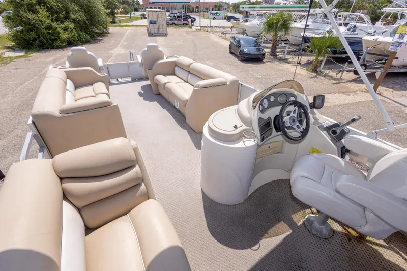 Slide: The Image of 2007 Crest 111 XRS pontoon boat interior with beige seating and steering console. - 22