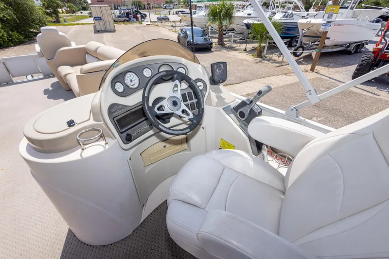 Slide: The Image of 2007 Crest 111 XRS boat dashboard with steering wheel and gauges in a marina setting. - 24