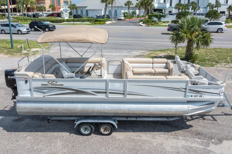 Slide: The Image of 2007 Crest 111 XRS pontoon boat with canopy on trailer, parked near road. - 2