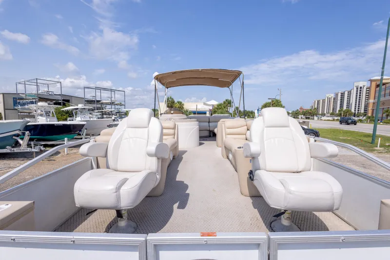 Slide: The Image of Pontoon boat with white seats, Crest 111 XRS 2007 model, parked near marina. - 16