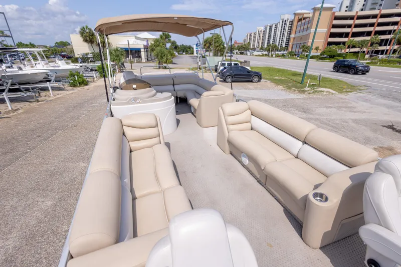 Slide: The Image of 2007 Crest 111 XRS pontoon boat with beige seating and canopy, parked near a road. - 17