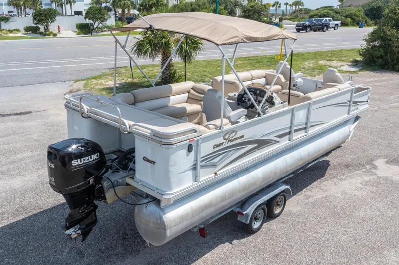 Slide: The Image of 2007 Crest 111 XRS pontoon boat with Suzuki motor on trailer, parked near road. - 32