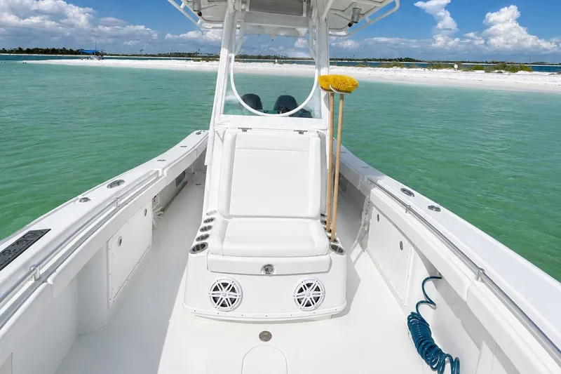 Slide: The Image of 2015 Yellowfin 26 Hybrid boat on turquoise water near sandy beach. - 13