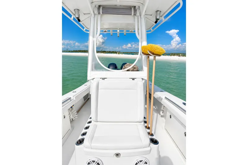 Slide: The Image of 2015 Yellowfin 26 Hybrid boat interior with white seating, ocean view, and cleaning brushes. - 14