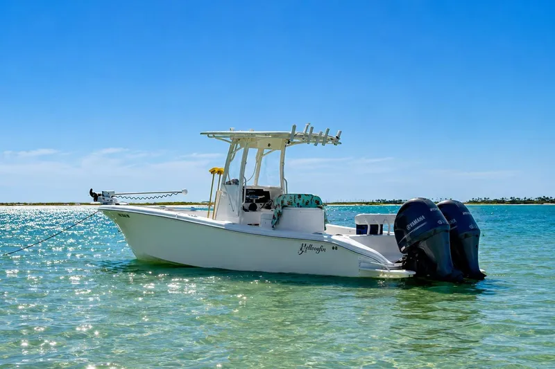 Slide: The Image of 2015 Yellowfin 26 Hybrid boat anchored in clear turquoise water under a bright blue sky. - 5
