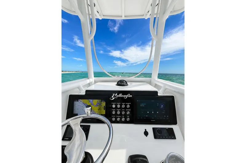 Slide: The Image of 2015 Yellowfin 26 Hybrid boat dashboard with navigation system, steering wheel, and ocean view. - 11