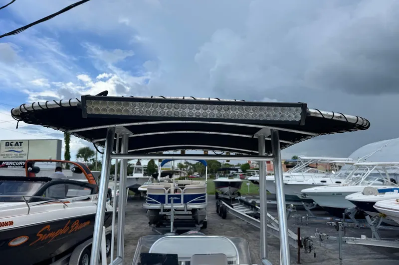 Slide: The Image of 2004 Sea Fox 225 Bay Fisher boat with T-top and LED light bar, docked under cloudy skies. - 31