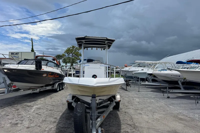 Slide: The Image of 2004 Sea Fox 225 Bay Fisher boat on trailer, surrounded by other boats, under cloudy sky. - 2