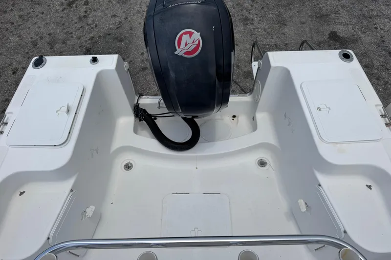 Slide: The Image of 2004 Sea Fox 225 Bay Fisher boat deck with motor, featuring storage compartments. - 19