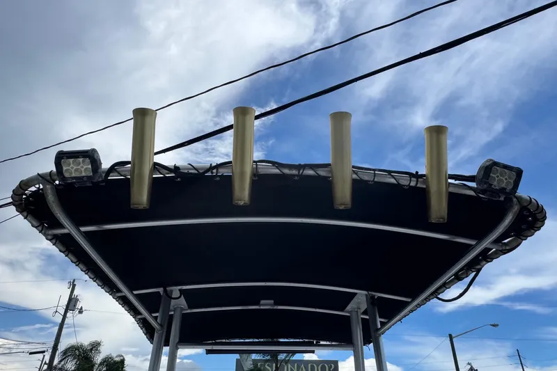 Slide: The Image of T-top of 2004 Sea Fox 225 Bay Fisher with rod holders and lights against cloudy sky. - 32