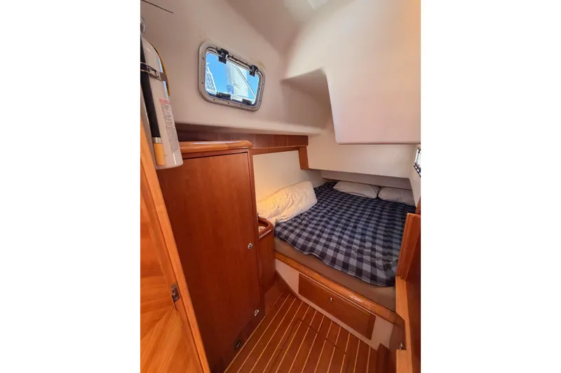 Slide: The Image of Cozy cabin interior of 2007 Saga 409 sailboat with wooden furnishings and plaid bedding. - 79