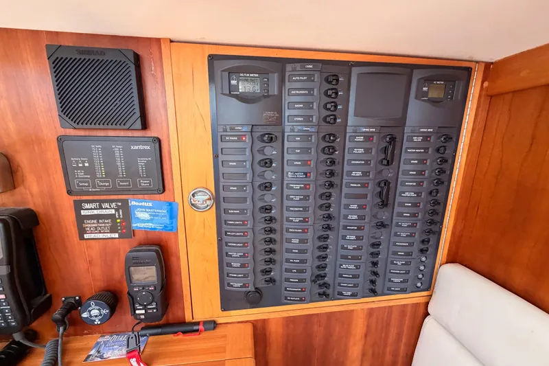 Slide: The Image of Electrical control panel on a 2007 Saga 409 boat, featuring various switches and meters. - 75