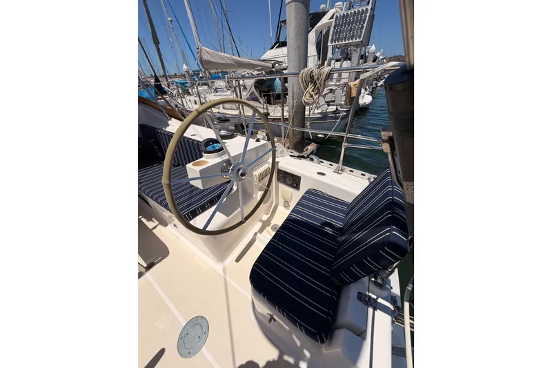 Slide: The Image of Cockpit of 2007 Saga 409 sailboat with striped cushions and steering wheel in marina. - 39