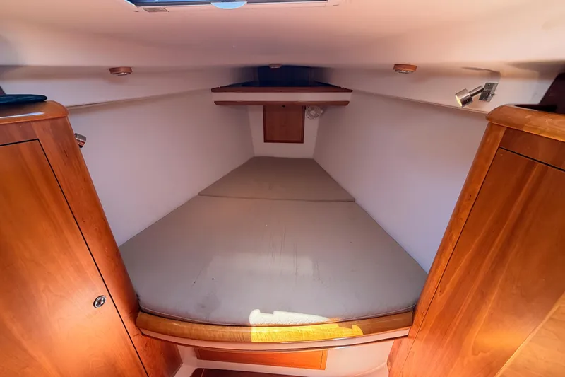 Slide: The Image of Cozy cabin interior of 2007 Saga 409 boat with wooden finish and cushioned bed. - 104