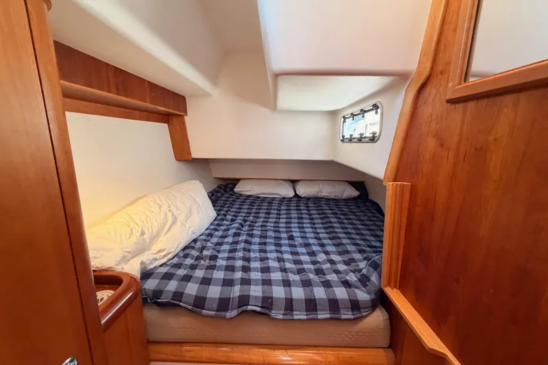 Slide: The Image of Cozy cabin interior of 2007 Saga 409 sailboat with plaid bedding and wooden accents. - 80