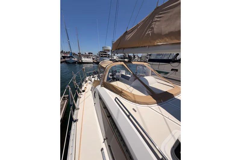 Slide: The Image of 2007 Saga 409 sailboat docked at marina, featuring beige canopy and sleek design. - 27