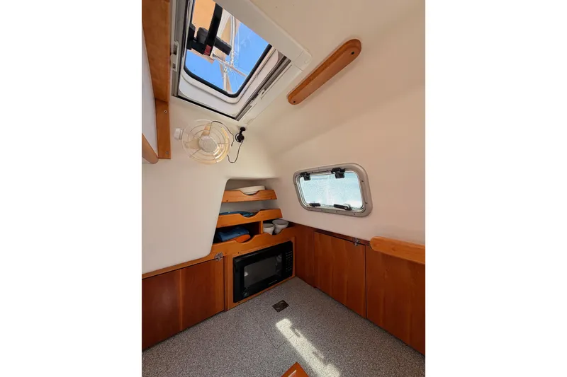 Slide: The Image of Interior of 2007 Saga 409 sailboat cabin with window, fan, and storage shelves. - 67