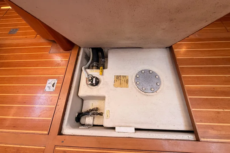 Slide: The Image of Underfloor compartment in a 2007 Saga 409 boat, showcasing storage and plumbing components. - 123