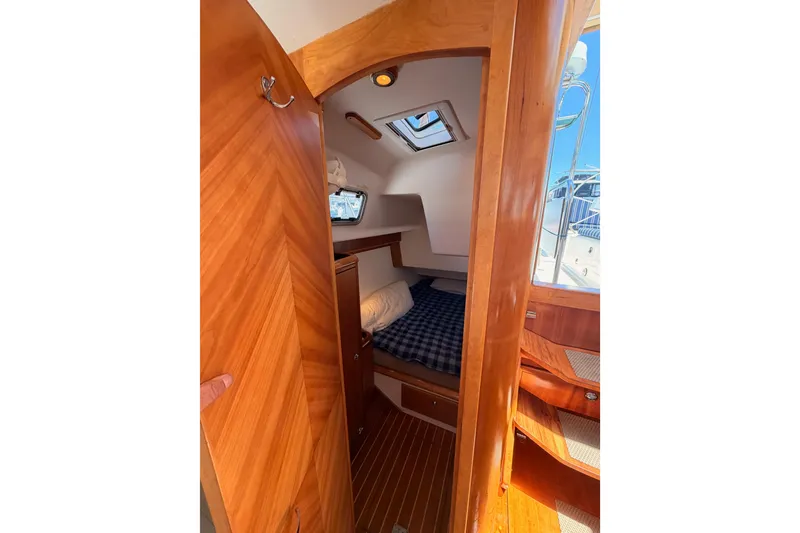 Slide: The Image of Cozy cabin interior of 2007 Saga 409 sailboat with wooden finish and checkered bedding. - 77