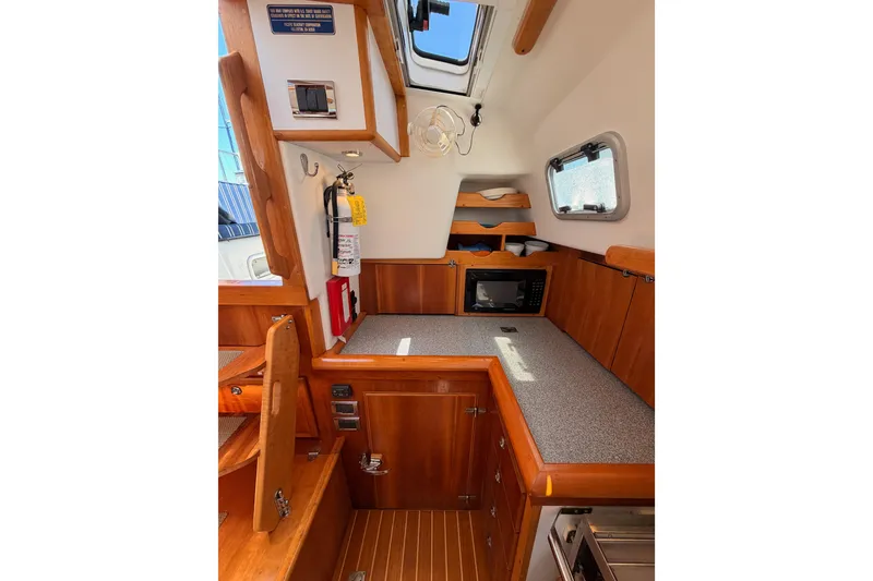Slide: The Image of Cozy interior of 2007 Saga 409 sailboat with wooden cabinetry and compact kitchen area. - 61