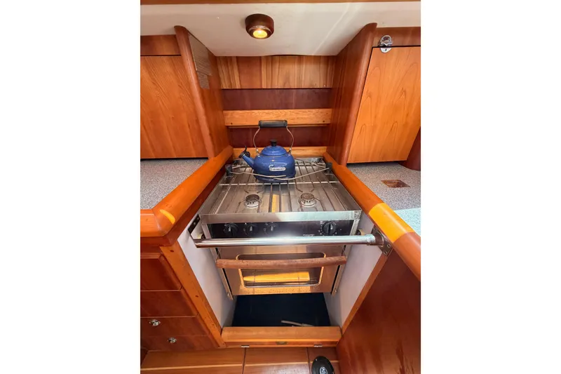 Slide: The Image of Compact wooden boat kitchen with stove, oven, and blue kettle, Saga 409, 2007 model. - 69