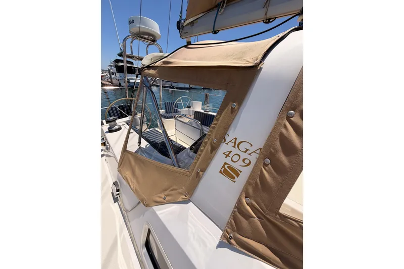Slide: The Image of Sailing yacht Saga 409, 2007 model, with tan canvas cover in a marina setting. - 29
