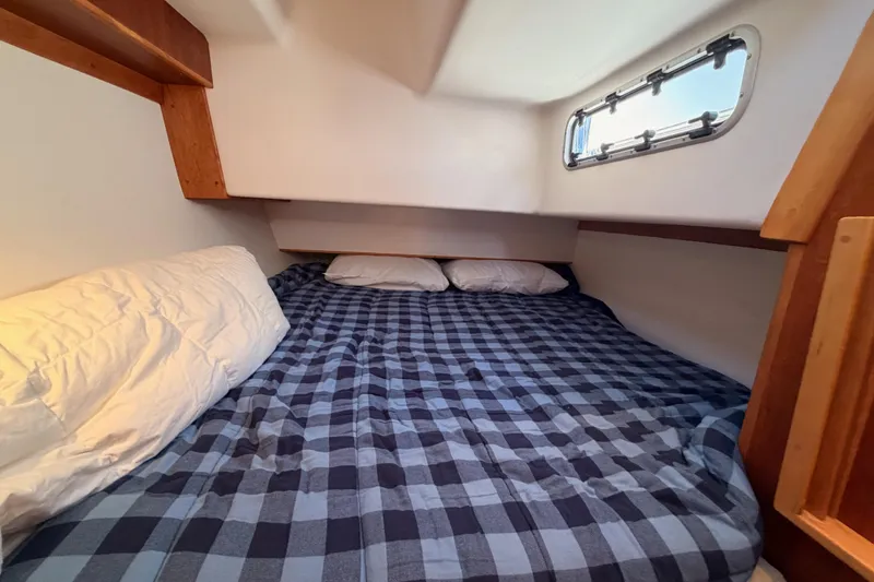 Slide: The Image of Cozy cabin bed with checkered bedding in 2007 Saga 409 boat. - 81