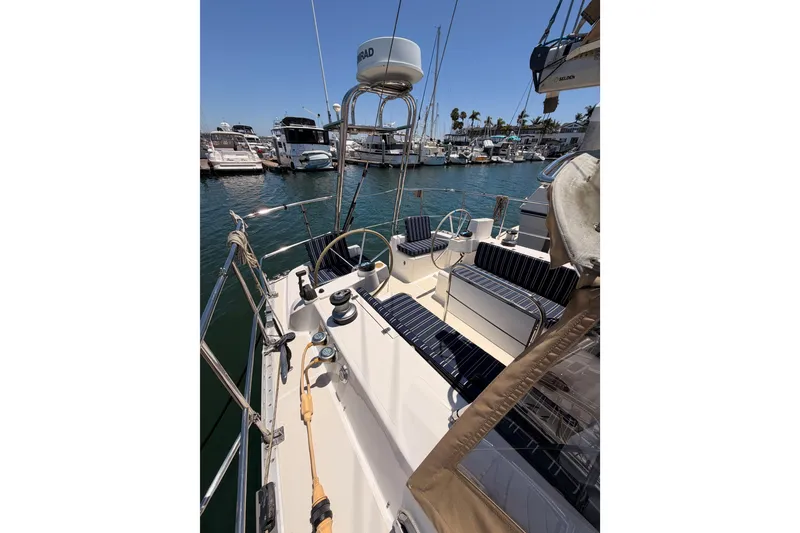 Slide: The Image of 2007 Saga 409 sailboat cockpit with striped seating, docked in a marina under clear skies. - 30