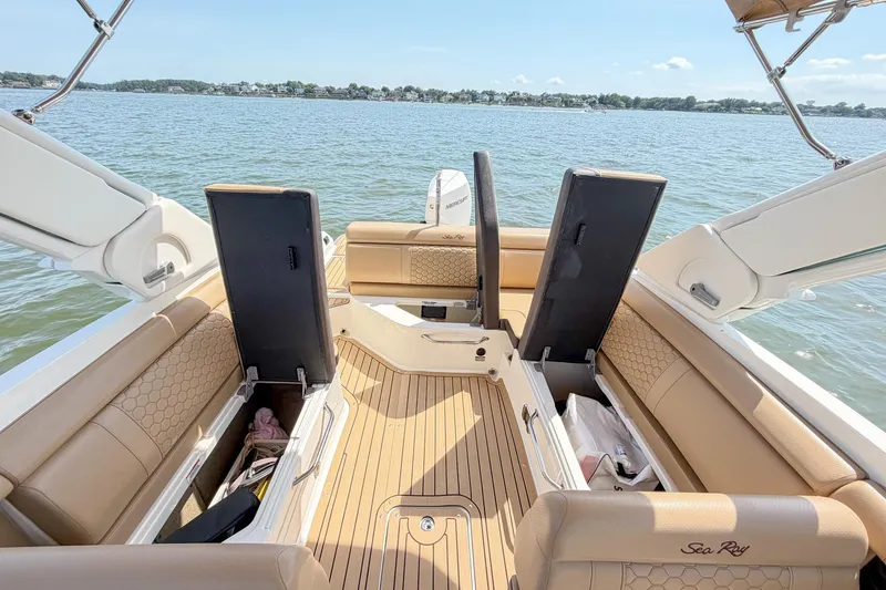 Slide: The Image of 2021 Sea Ray SDX 270 Outboard boat interior with open storage compartments on a sunny day. - 20