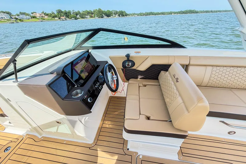 Slide: The Image of 2021 Sea Ray SDX 270 Outboard boat interior with tan seating and modern dashboard. - 8
