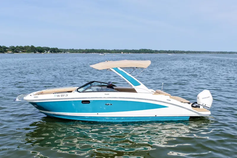Slide: The Image of 2021 Sea Ray SDX 270 Outboard boat on calm water, featuring a sleek design and canopy. - 2