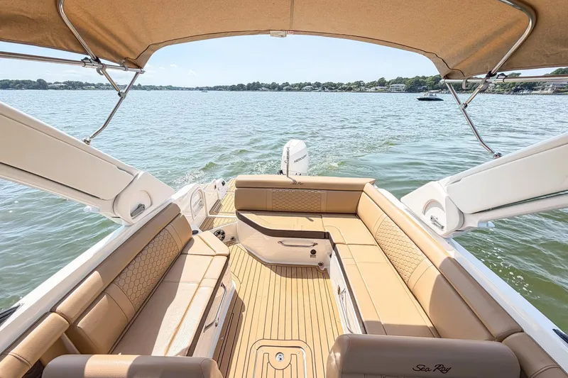 Slide: The Image of 2021 Sea Ray SDX 270 Outboard boat interior with tan seating on a sunny lake. - 6