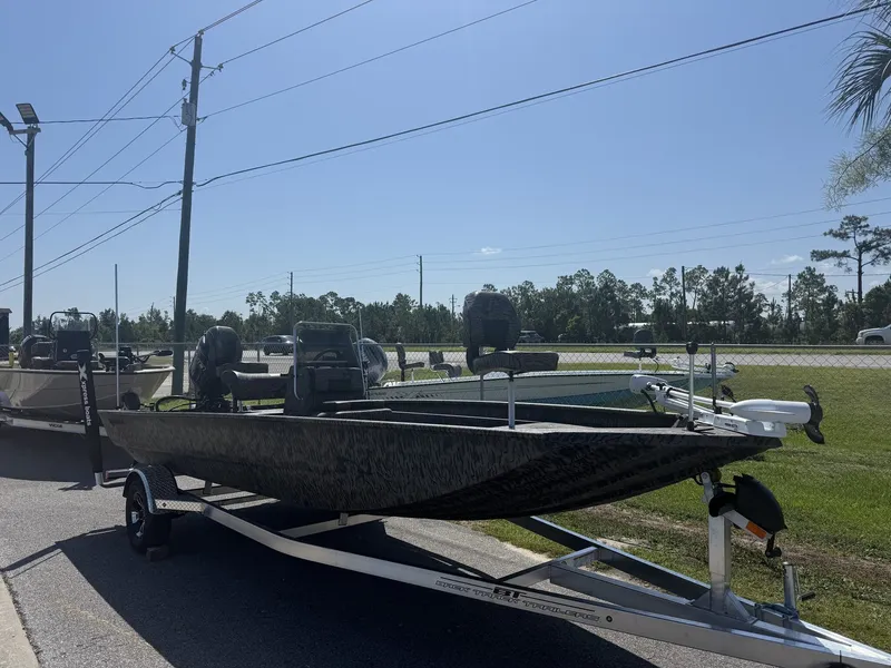The Image of A 2027 Xpress XP20CC boat on a trailer beside a road. - 1