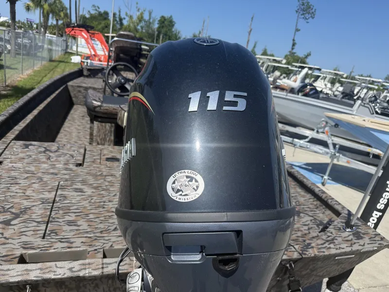 Slide: The Image of An Xpress XP20CC boat with a 115 HP outboard motor, parked at a boatyard. - 3