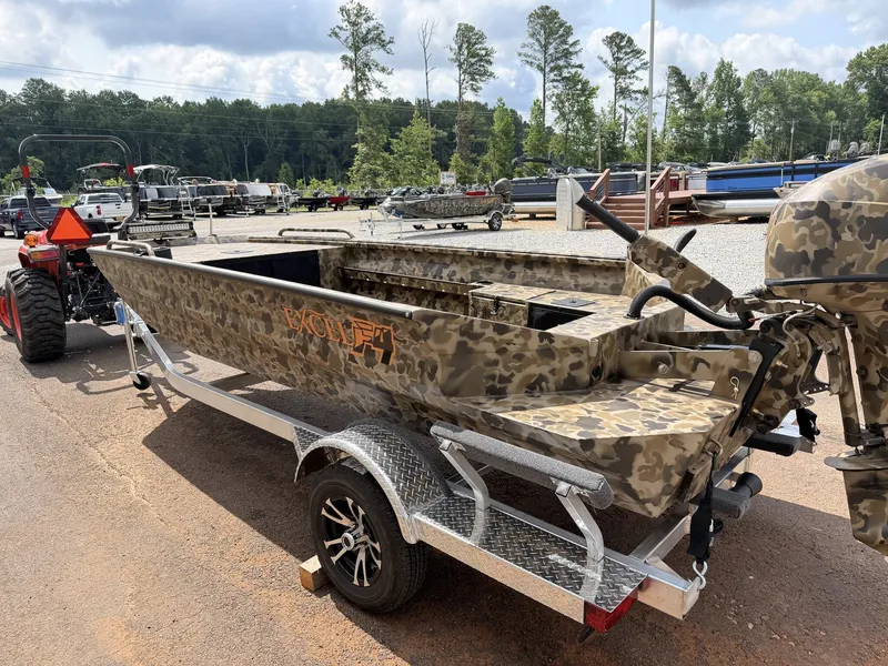 Slide: The Image of An Excel Viper F4 1751 aluminum boat on a trailer, surrounded by trees and other boats. - 3