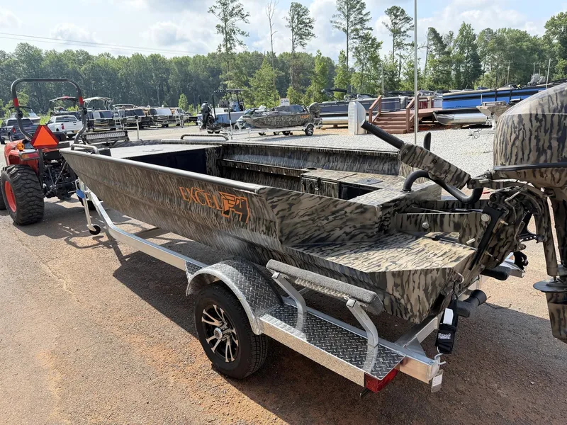 Slide: The Image of Excel Viper F4 1751 on an aluminum trailer, surrounded by trees and other boats. - 3