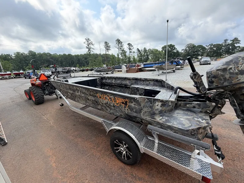 Slide: The Image of An Excel Viper F4 1751 boat on an aluminum trailer, surrounded by trees and vehicles. - 3